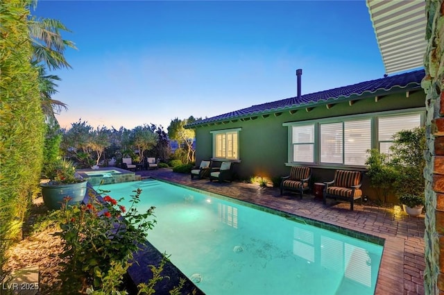 748 Puerto Real Ct, Las Vegas, NV 89138 - pool at dusk featuring a patio and a pool with connected hot tub
