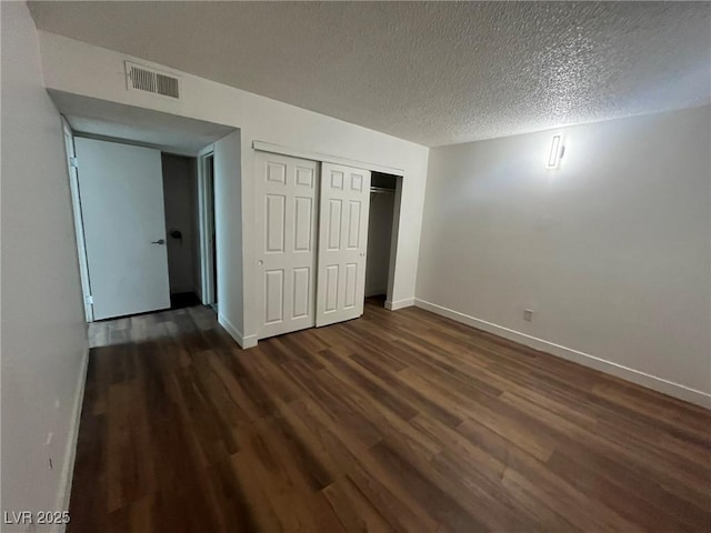 3585 Arville St Unit 403A, Las Vegas, NV 89103 - unfurnished bedroom with wood finished floors, baseboards, a textured ceiling, and a closet