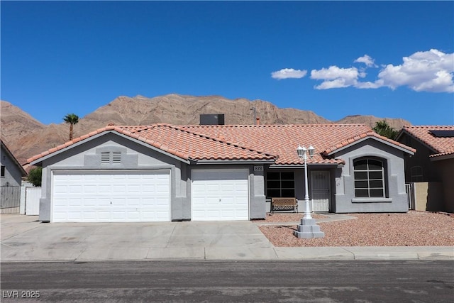 878 Samoy St, Las Vegas, NV 89110 - view of front of property featuring a tiled roof, a garage, driveway, a mountain view, and stucco siding