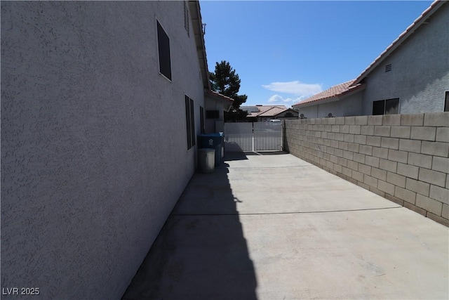 878 Samoy St, Las Vegas, NV 89110 - view of side of property featuring stucco siding, concrete driveway, and a patio area