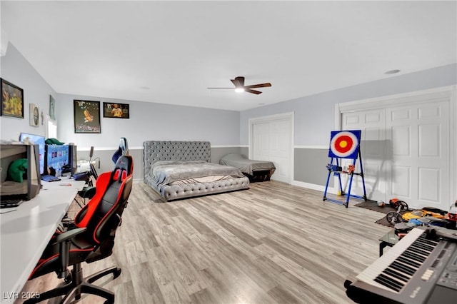 2131 Diamond Bar Dr, Las Vegas, NV 89117 - bedroom with an office area, wood finished floors, a ceiling fan, baseboards, and multiple closets