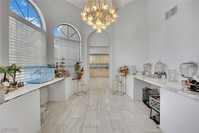 2131 Diamond Bar Dr, Las Vegas, NV 89117 - interior space with high vaulted ceiling, a chandelier, pendant lighting, arched walkways, and backsplash