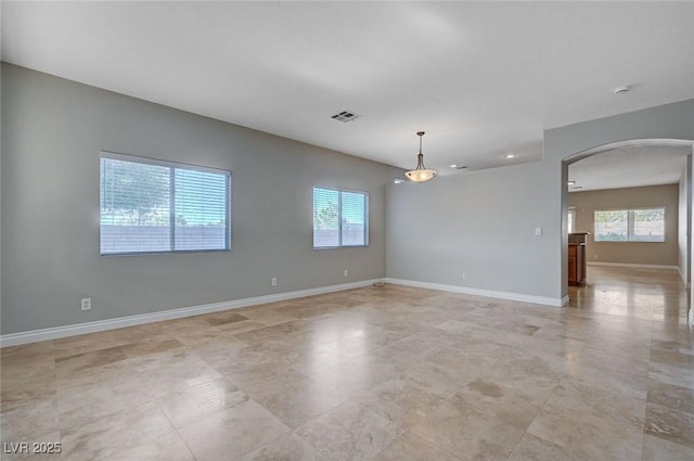 10518 Santerno St, Las Vegas, NV 89141 - spare room with arched walkways, healthy amount of natural light, baseboards, and light tile patterned floors