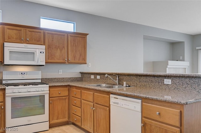 10518 Santerno St, Las Vegas, NV 89141 - kitchen featuring white appliances, a sink, a peninsula, light stone countertops, and brown cabinets