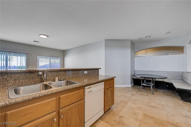10518 Santerno St, Las Vegas, NV 89141 - kitchen with dishwasher, a sink, arched walkways, and brown cabinetry