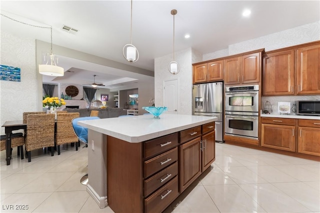 5872 Revital Ct, Las Vegas, NV 89131 - kitchen with stainless steel appliances, light countertops, a ceiling fan, hanging light fixtures, and light tile patterned floors