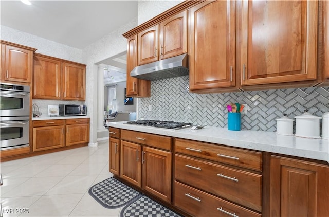 5872 Revital Ct, Las Vegas, NV 89131 - kitchen with under cabinet range hood, appliances with stainless steel finishes, backsplash, and light countertops