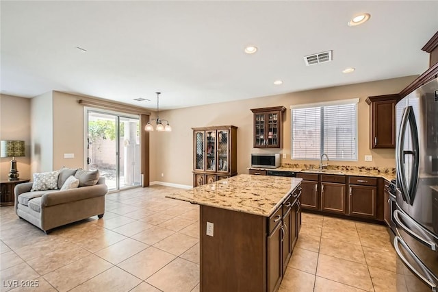 10121 Iron Wood Peak Ave, Las Vegas, NV 89166 - kitchen featuring open floor plan, light tile patterned floors, appliances with stainless steel finishes, dark brown cabinets, and a chandelier
