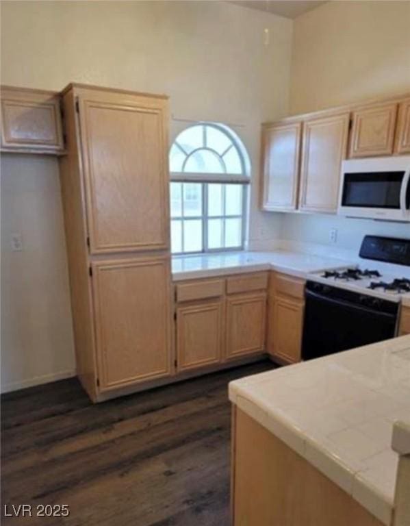 3125 N Buffalo Dr Unit 2104, Las Vegas, NV 89128 - kitchen with white microwave, range with gas cooktop, light brown cabinets, and dark wood-type flooring