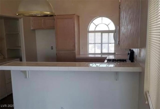3125 N Buffalo Dr Unit 2104, Las Vegas, NV 89128 - kitchen with tile countertops, a peninsula, and a breakfast bar