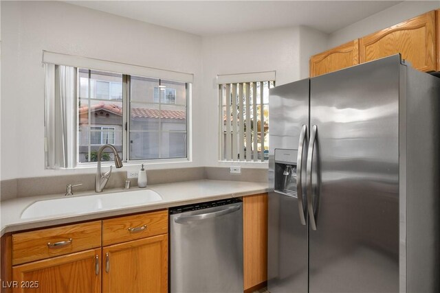3331 Cheltenham St, Las Vegas, NV 89129 - kitchen featuring stainless steel appliances, a sink, light countertops, and brown cabinetry