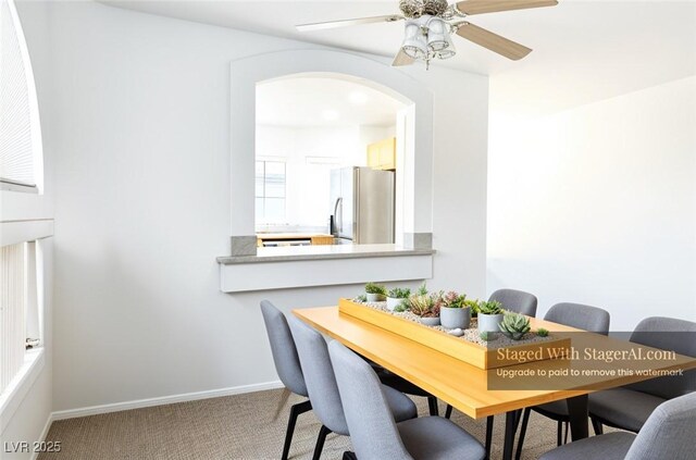 3331 Cheltenham St, Las Vegas, NV 89129 - carpeted dining room with arched walkways, a ceiling fan, and baseboards