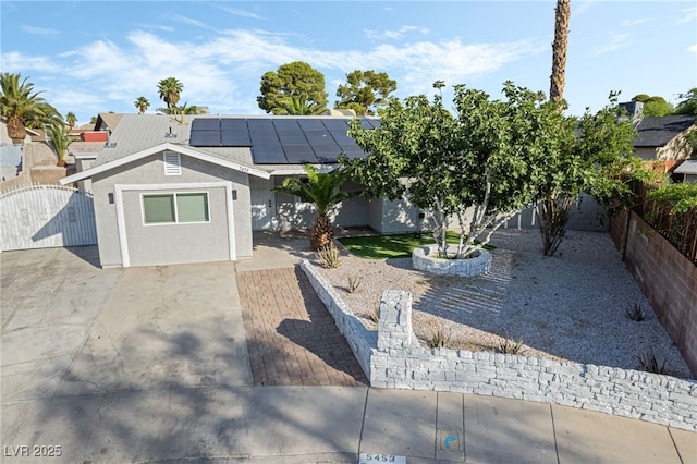 5453 Yvonne Cir, Las Vegas, NV 89122 - view of front of home with a gate, a fenced backyard, solar panels, and stucco siding