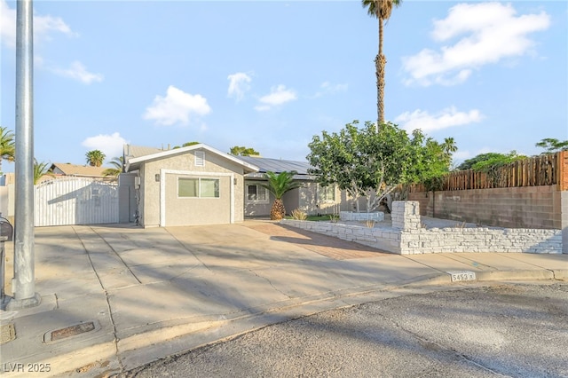 5453 Yvonne Cir, Las Vegas, NV 89122 - ranch-style home featuring a gate, roof mounted solar panels, stucco siding, a metal roof, and driveway