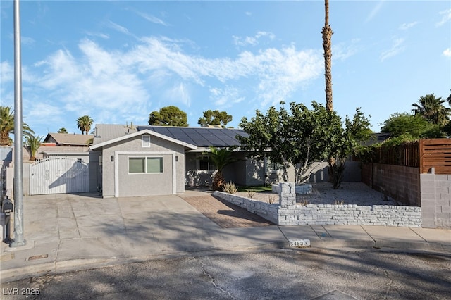 5453 Yvonne Cir, Las Vegas, NV 89122 - view of front facade featuring a gate, roof mounted solar panels, and stucco siding
