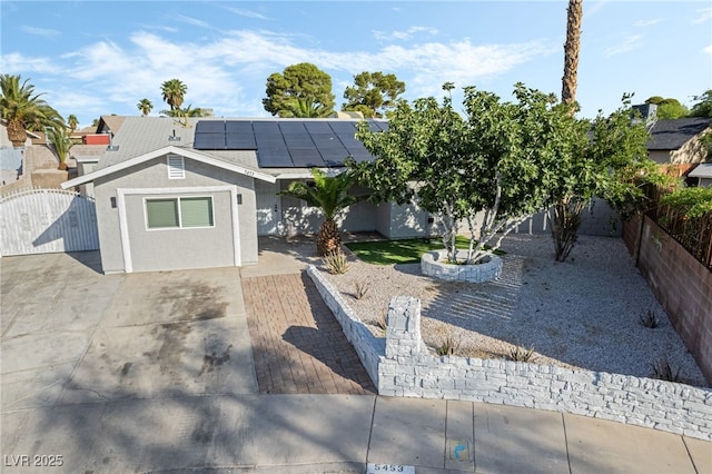 5453 Yvonne Cir, Las Vegas, NV 89122 - view of front of house featuring a gate, a fenced backyard, solar panels, and stucco siding