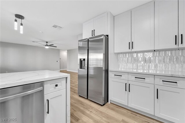 5453 Yvonne Cir, Las Vegas, NV 89122 - kitchen featuring appliances with stainless steel finishes, light wood-type flooring, a ceiling fan, and white cabinets