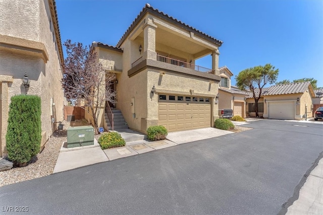 7852 Running Doe Ct, Las Vegas, NV 89149 - view of front facade with stucco siding, a tiled roof, a balcony, and driveway