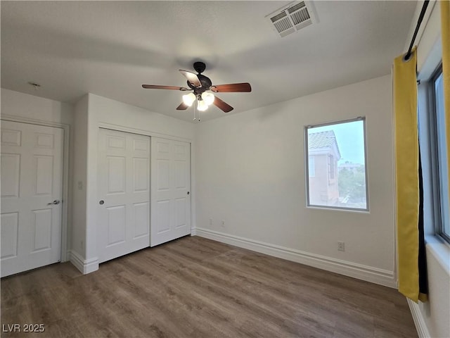 6638 Babys Tear Pl, Las Vegas, NV 89148 - unfurnished bedroom with wood finished floors, baseboards, a closet, and a ceiling fan