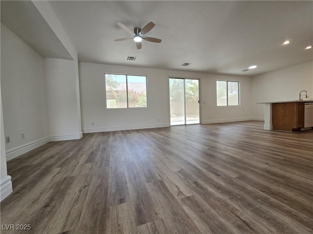 6638 Babys Tear Pl, Las Vegas, NV 89148 - unfurnished living room featuring dark wood-style flooring, baseboards, ceiling fan, recessed lighting, and a sink