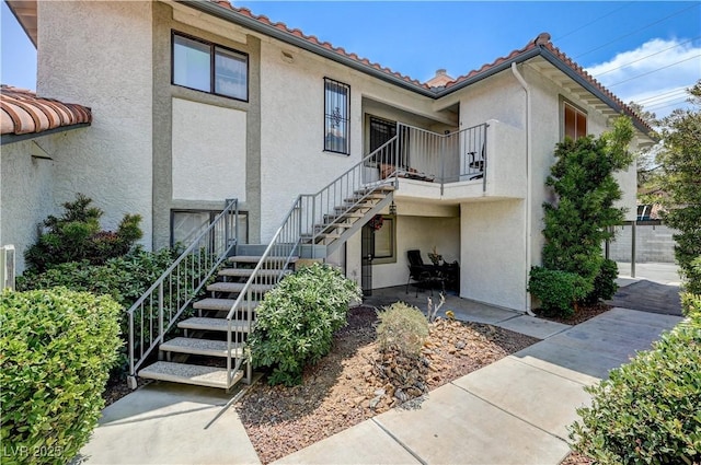 6735 W Charleston Blvd Unit 4, Las Vegas, NV 89146 - view of front of house featuring stairs, stucco siding, a balcony, and a tile roof