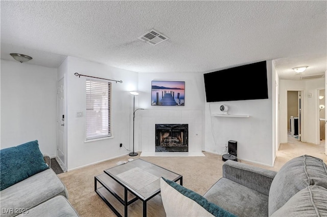 6735 W Charleston Blvd Unit 4, Las Vegas, NV 89146 - living room featuring light carpet, a tile fireplace, a textured ceiling, and baseboards