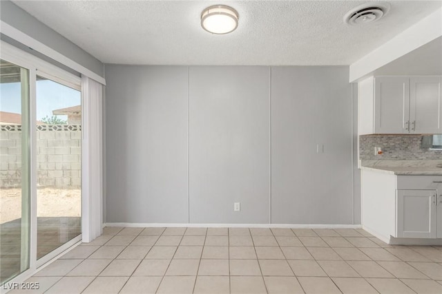 2432 Spanish Ct, Las Vegas, NV 89108 - unfurnished dining area with a textured ceiling and baseboards
