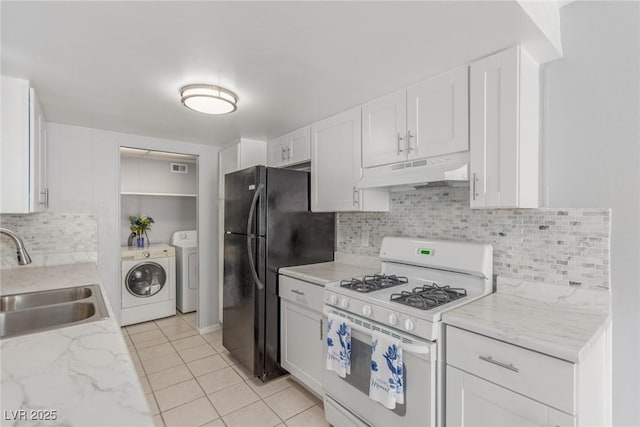 2432 Spanish Ct, Las Vegas, NV 89108 - kitchen featuring under cabinet range hood, white gas stove, a sink, washing machine and clothes dryer, and decorative backsplash