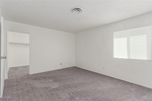 2432 Spanish Ct, Las Vegas, NV 89108 - unfurnished bedroom featuring carpet flooring, a textured ceiling, baseboards, and a walk in closet