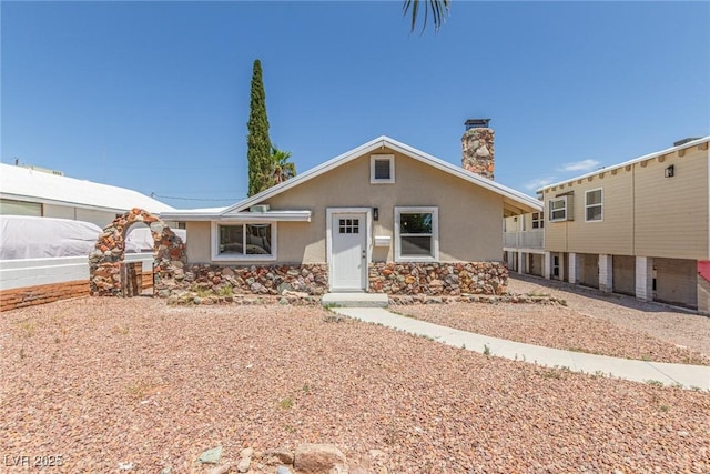 659 D Ave, Boulder City, NV 89005 - view of front of house featuring stucco siding, a chimney, and stone siding