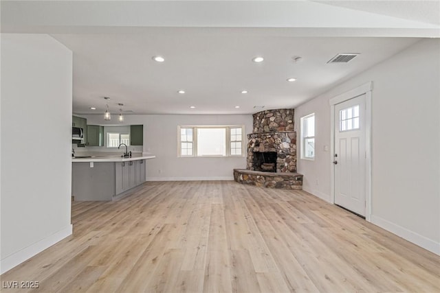 659 D Ave, Boulder City, NV 89005 - unfurnished living room featuring a sink, light wood-style floors, a stone fireplace, recessed lighting, and baseboards