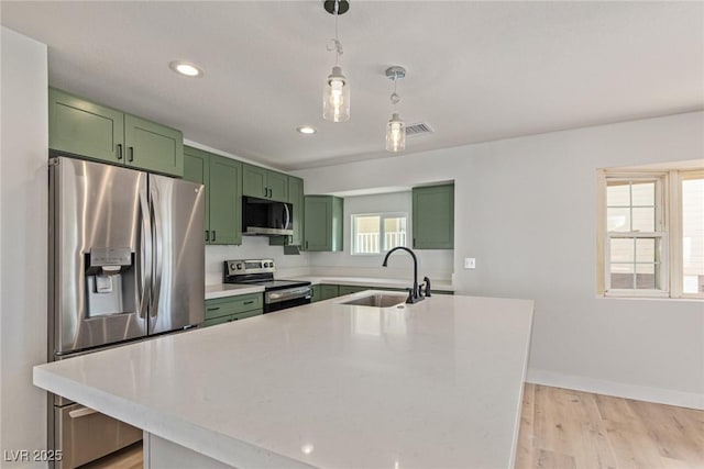 659 D Ave, Boulder City, NV 89005 - kitchen with green cabinets, appliances with stainless steel finishes, a sink, light countertops, and light wood finished floors