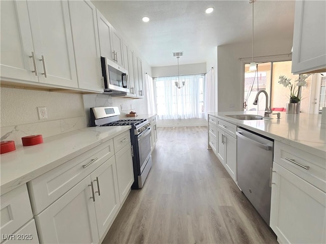 8545 Summer Vista Ave, Las Vegas, NV 89145 - kitchen featuring stainless steel appliances, a sink, light wood-type flooring, white cabinetry, and recessed lighting