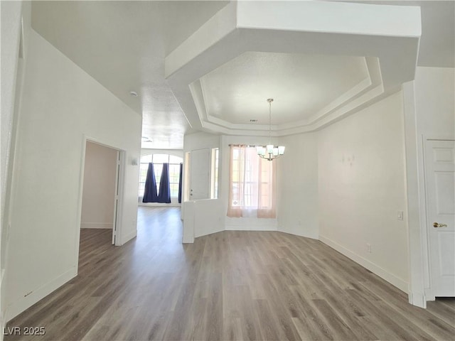 8545 Summer Vista Ave, Las Vegas, NV 89145 - unfurnished room with a tray ceiling, a chandelier, wood finished floors, and baseboards