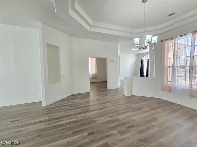 8545 Summer Vista Ave, Las Vegas, NV 89145 - unfurnished dining area featuring a chandelier, a raised ceiling, wood finished floors, and baseboards