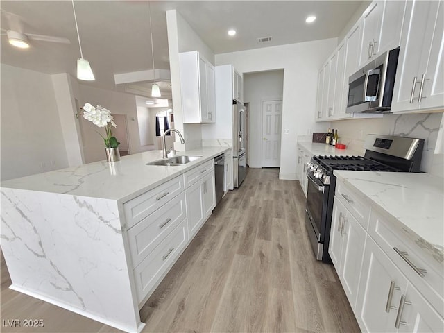 8545 Summer Vista Ave, Las Vegas, NV 89145 - kitchen featuring appliances with stainless steel finishes, a sink, light wood-style flooring, white cabinets, and recessed lighting