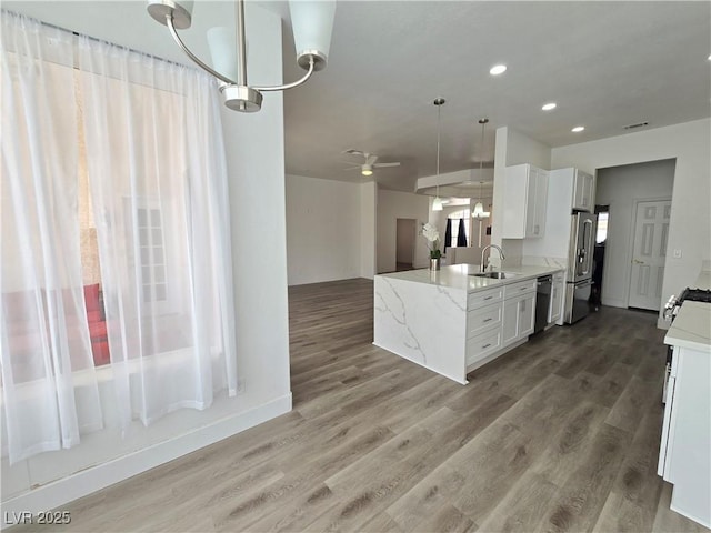 8545 Summer Vista Ave, Las Vegas, NV 89145 - kitchen featuring a sink, stainless steel appliances, a ceiling fan, wood finished floors, and light stone counters