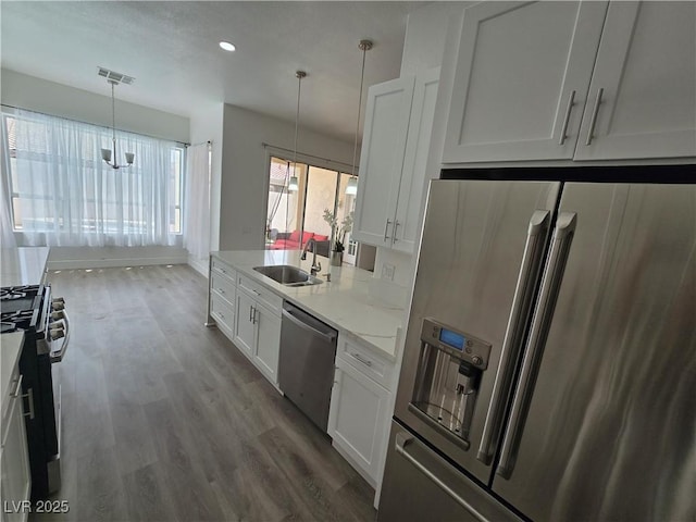 8545 Summer Vista Ave, Las Vegas, NV 89145 - kitchen featuring appliances with stainless steel finishes, a sink, wood finished floors, white cabinetry, and recessed lighting