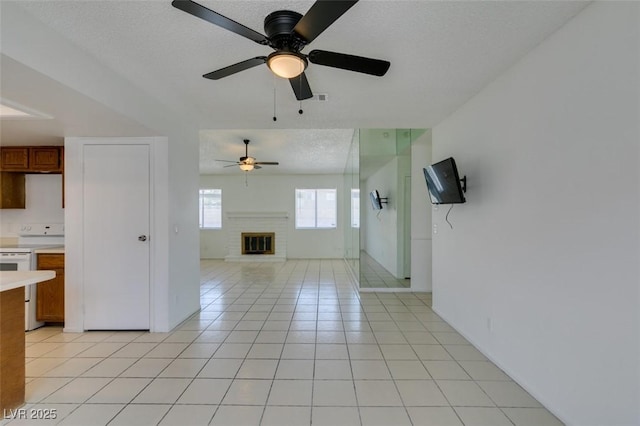 2116 Cameron St, Las Vegas, NV 89102 - unfurnished living room featuring ceiling fan, light tile patterned floors, a fireplace, a textured ceiling, and baseboards