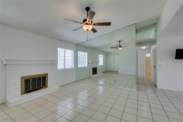 2116 Cameron St, Las Vegas, NV 89102 - unfurnished living room with a fireplace, a ceiling fan, a textured ceiling, and light tile patterned floors