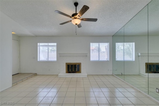 2116 Cameron St, Las Vegas, NV 89102 - unfurnished living room featuring a brick fireplace, a textured ceiling, tile patterned flooring, and ceiling fan