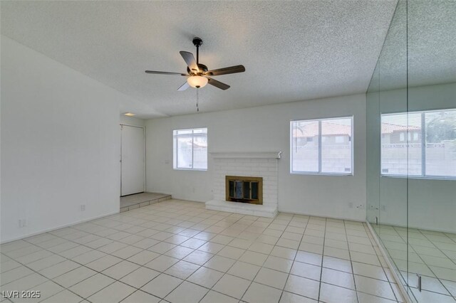 2116 Cameron St, Las Vegas, NV 89102 - unfurnished living room featuring ceiling fan, a textured ceiling, light tile patterned floors, and a fireplace