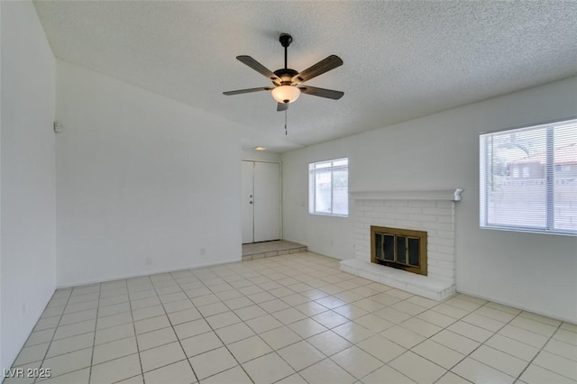 2116 Cameron St, Las Vegas, NV 89102 - unfurnished living room with ceiling fan, a brick fireplace, a textured ceiling, and light tile patterned floors
