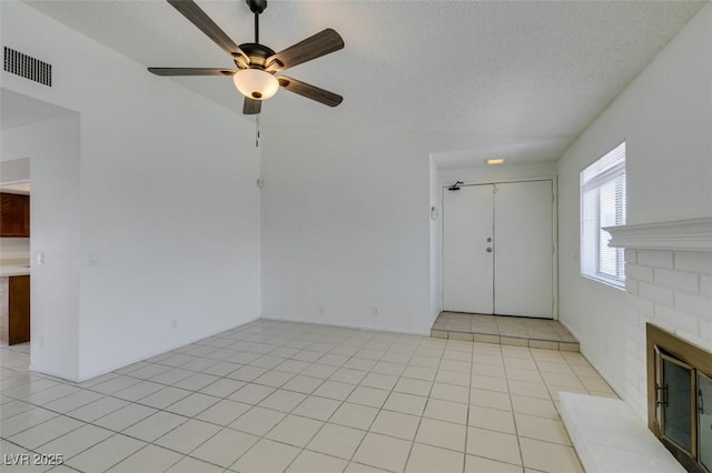 2116 Cameron St, Las Vegas, NV 89102 - unfurnished living room with a glass covered fireplace, ceiling fan, light tile patterned floors, and a textured ceiling