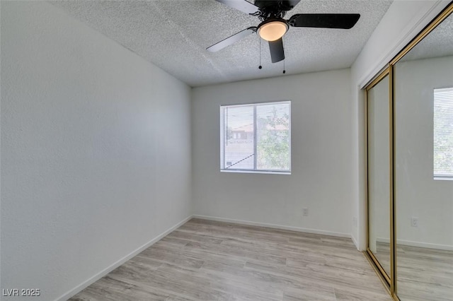 2116 Cameron St, Las Vegas, NV 89102 - unfurnished bedroom featuring a textured ceiling, a closet, multiple windows, light wood finished floors, and ceiling fan
