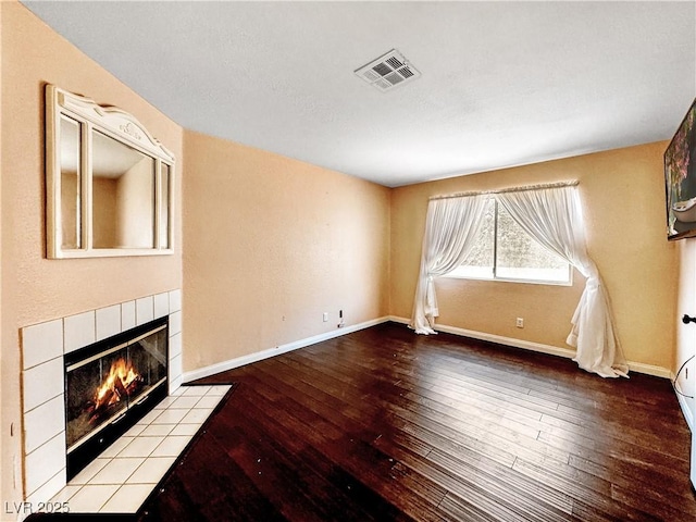 2204 Short Pine Dr, Las Vegas, NV 89108 - unfurnished living room featuring a tiled fireplace, hardwood / wood-style floors, and baseboards