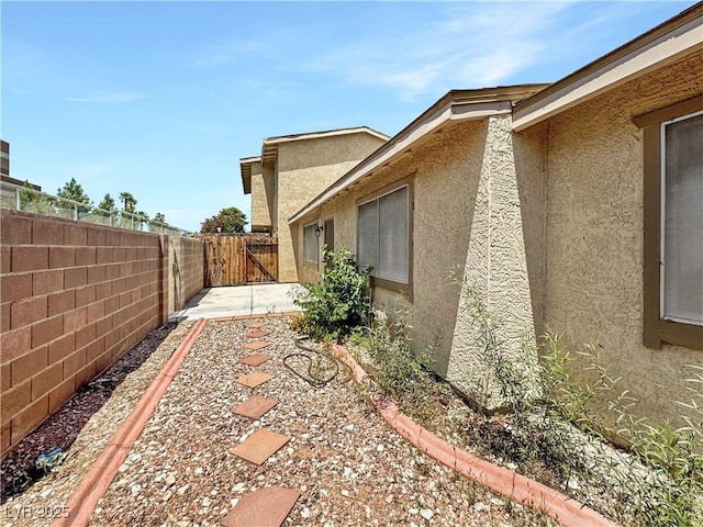 2204 Short Pine Dr, Las Vegas, NV 89108 - view of side of property featuring stucco siding, a fenced backyard, and a patio area