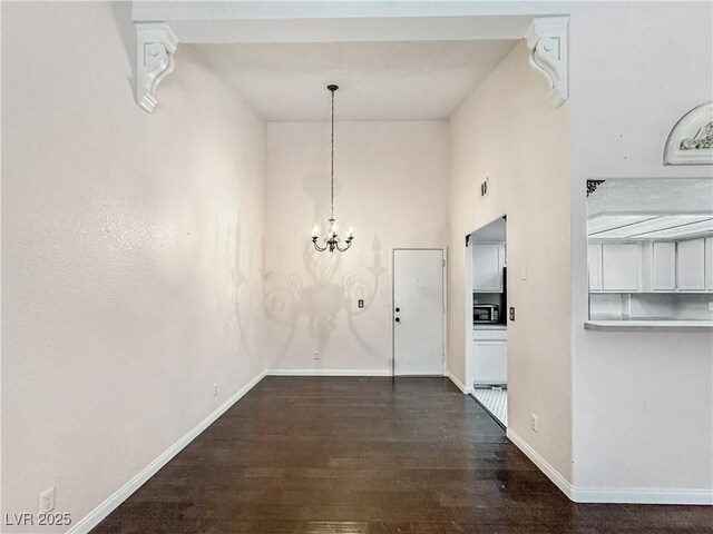 2204 Short Pine Dr, Las Vegas, NV 89108 - unfurnished dining area with dark wood-style floors, baseboards, a chandelier, and a high ceiling