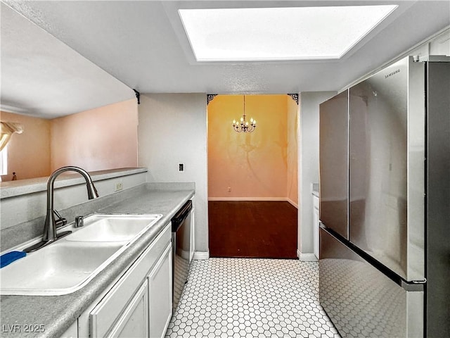 2204 Short Pine Dr, Las Vegas, NV 89108 - kitchen featuring appliances with stainless steel finishes, a sink, a chandelier, baseboards, and white cabinets