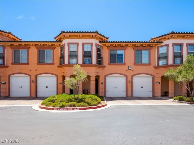 30 Via Vasari Unit 103, Henderson, NV 89011 - view of property featuring stucco siding, a garage, and a tile roof